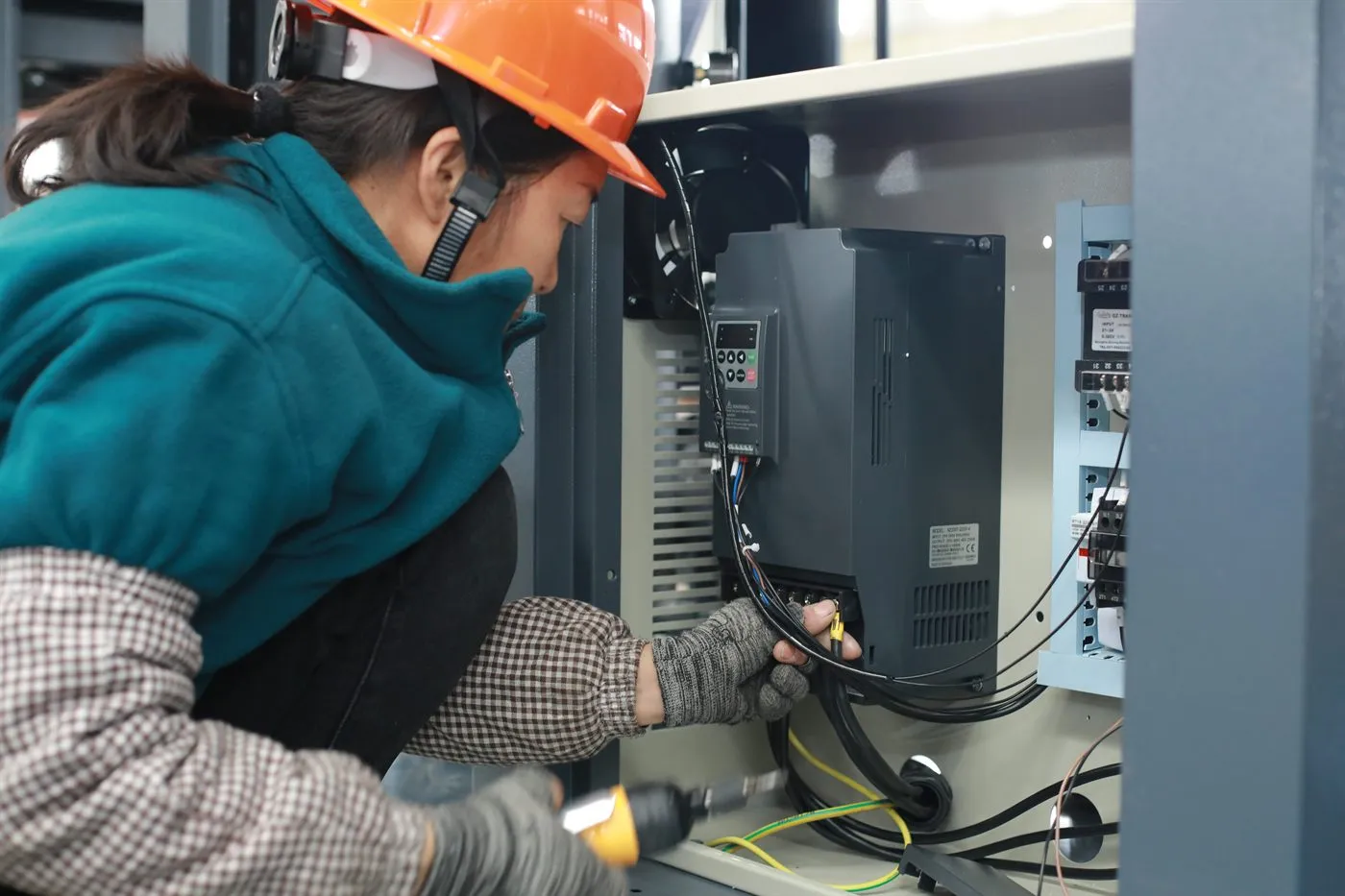 Air compressor 33 Technician inspecting the electrical panel and variable-frequency drive of an industrial air compressor